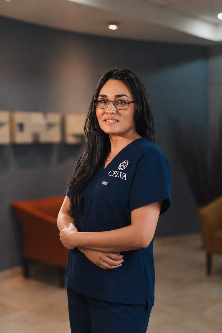 Celva stem cell lab technician in CELVA scrubs, arms folded, standing in the clinic interior