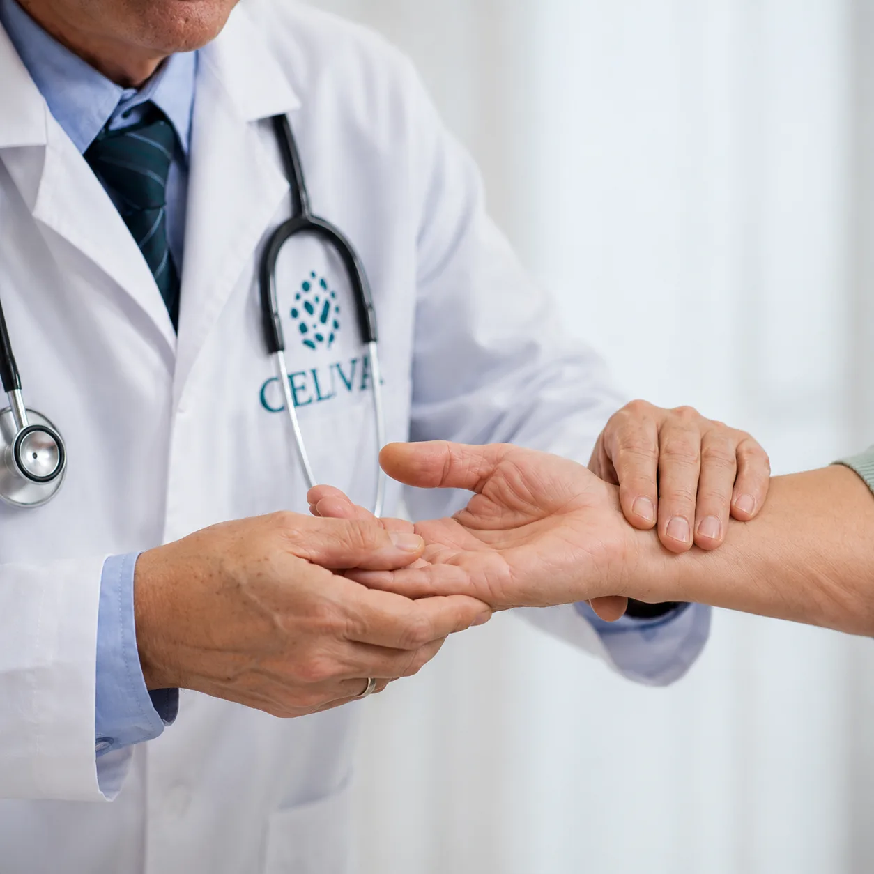 Celva physician examining a patient's hand and thumb joint