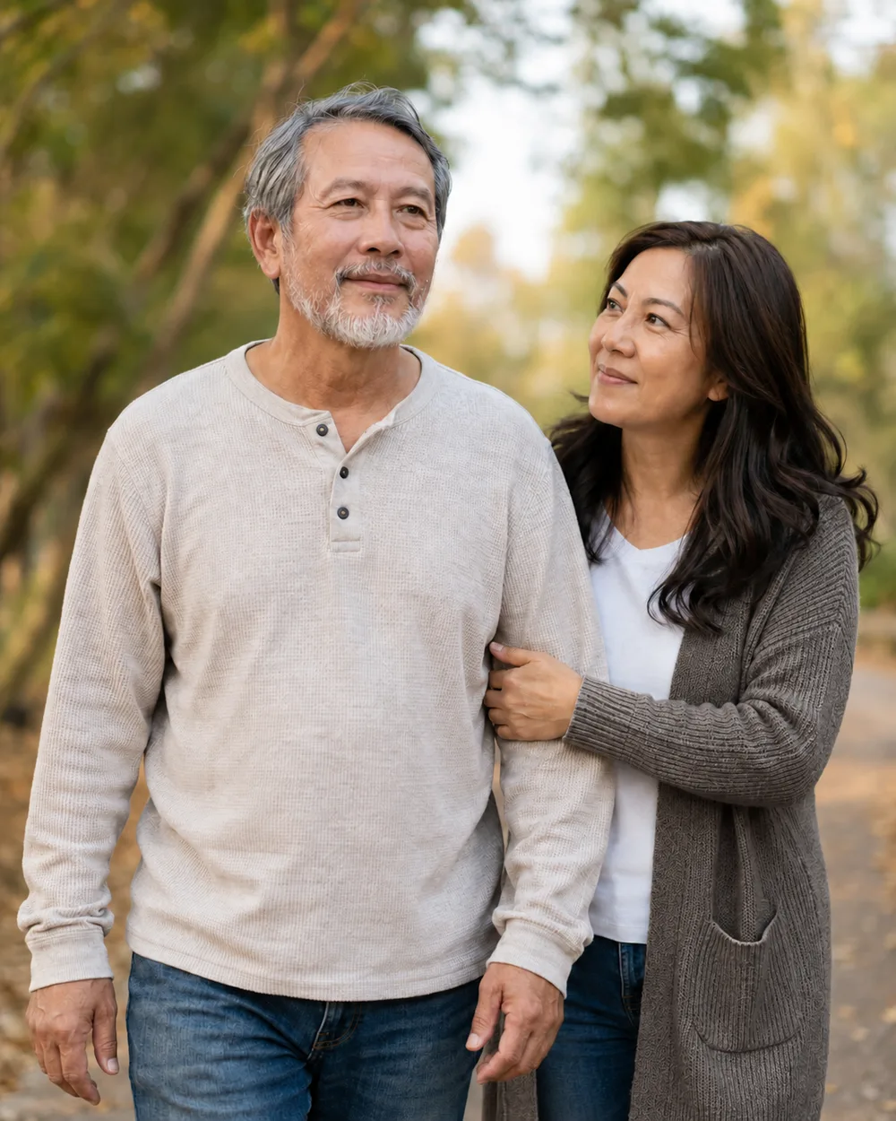 A man walking a wooded path with his wife's arm through his